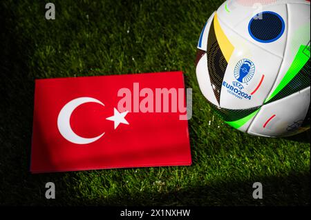 HAMBURG, DEUTSCHLAND, 17. APRIL 2024: Türkische Nationalflagge und offizieller Fußball des Fußballturniers Euro 2024 in Deutschland auf grünem Gras platziert. Bla Stockfoto