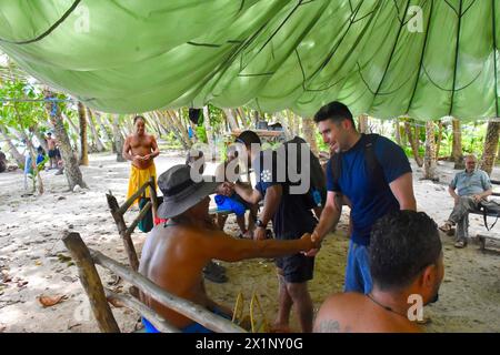 Woleai, Mikronesien, Föderierte Staaten Von. 12. April 2024. US-Küstenwache Lt. Ray Cerrato, befehlshabender Offizier und Petty Officer 2. Klasse Eugene Halishlius, rechts, vom Schnellreaktionsschneider der Sentinel-Klasse USCGC Oliver Henry begrüßt die Bewohner nach der Ankunft mit Nothilfe. Techniker und ein Umkehrosmose-System zur Linderung des Trinkwassermangels durch Dürre auf der abgelegenen Insel, 12. April 2024 in Woleai, Bundesstaat Yap, Föderierte Staaten von Mikronesien. Quelle: CWO Sara Muir/USCG/Alamy Live News Stockfoto