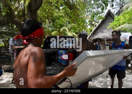 Woleai, Mikronesien, Föderierte Staaten Von. 12. April 2024. Anwohner helfen beim Entladen von Solarpaneelen, um eine Umkehrosmose-Anlage zu betreiben, die von der Crew des Schnellreaktionsschneiders USCGC Oliver Henry der Sentinel-Klasse geliefert wird, um den Mangel an Frischwasser durch Dürre auf der abgelegenen Insel zu lindern, 12. April 2024 in Woleai, Yap State, Föderierte Staaten von Mikronesien. Quelle: CWO Sara Muir/USCG/Alamy Live News Stockfoto