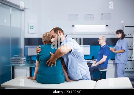 Krankenschwester in blauen Peelings, die alte Frau mit Rücken- und Wirbelsäulenschmerzen zur körperlichen Erholung behandelt. Chiropraktische Ärztin bei pensioniertem Patienten mit Rückenmarksverletzung und orthopädischer Betreuung. Stockfoto