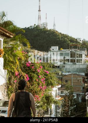 Flacher Blick auf den Hügel des Cross Aussichtspunkts in Puerto Vallarta, Mexiko, mit einer Frau, die im Vordergrund läuft. Stockfoto