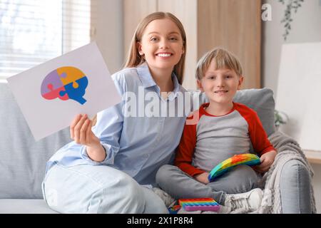 Eine Psychologin mit einem kleinen Jungen, der im Amt spielt. Weltautismus-Bewusstseinstag Stockfoto