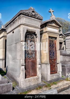 PARIS, FRANKREICH - 5. APRIL 2023: Zwei Familienkrypten stehen nebeneinander auf dem Friedhof Pere Lachaise in Paris. Stockfoto