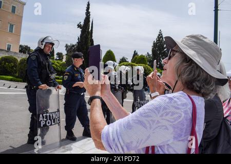 Athen, Griechenland. 17. April 2024. Touristen bestehen darauf, Fotos vom Wachwechsel auf dem Syntagma-Platz zu machen, trotz der starken Präsenz der Polizei gegen Aufstände aufgrund der Protestmärsche. Tausende von Menschen gingen während eines 24-stündigen landesweiten Streiks auf die Straßen der griechischen Hauptstadt und verurteilten die steigende Armut und die rasante Inflation, die Lohnerhöhungen und die Wiederherstellung von Tarifverträgen forderte. Quelle: Dimitris Aspiotis/Alamy Live News Stockfoto