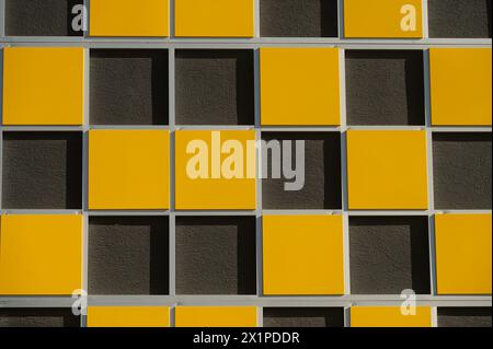 Nahaufnahme der Struktur der Gebäudewand. Gelbe und schwarze Farben an der Gebäudewand. Stockfoto