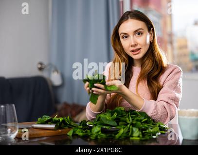 Glückliches Mädchen, das köstlichen Spinatsalat aus der Nähe macht Stockfoto