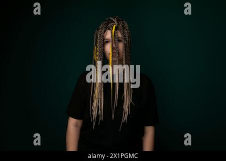 Mann mit Dreadlocks, der vor grünem Hintergrund steht Stockfoto