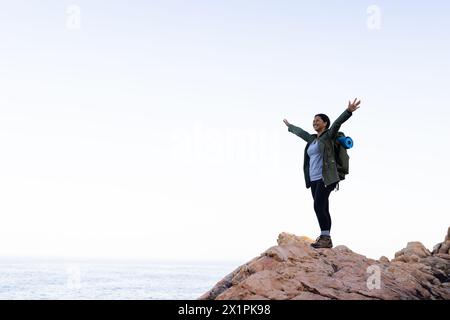 Birassische Wanderer steht auf dem Gipfel des Berges, Arme weit offen, Kopierraum Stockfoto