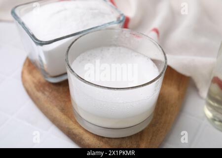 Chemische Reaktion von Essig und Backnatron in Glasschale auf weißem Tisch, Großaufnahme Stockfoto