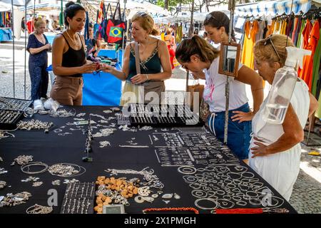 Touristen/Besucher kaufen Schmuck an Einem Verkaufsstand auf dem Ipanema Sunday Market (Hippie Fair) in Rio de Janeiro, Bundesstaat Rio de Janeiro, Brasilien. Stockfoto