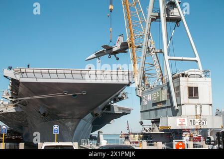 NORFOLK, Virginia (15. April 2024) Ein Kran, der von Naval Facilities Engineering Systems Command betrieben wird, hebt ein Trainingsflugzeug zur Schadenskontrolle in der Luftfahrt auf das Flugdeck des weltweit größten Flugzeugträgers USS Gerald R. Ford (CVN 78), 15. April 2024, Ford befindet sich derzeit an der Pier-Seite der Marinestation Norfolk und führt routinemäßige Wartungsarbeiten durch. (Foto der U.S. Navy von Seaman Apprentice Gladjimi Balisage, Spezialist für Massenkommunikation) Stockfoto