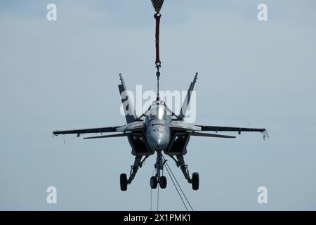 NORFOLK, Virginia (15. April 2024) Ein Kran, der von Naval Facilities Engineering Systems Command betrieben wird, hebt ein Trainingsflugzeug zur Schadenskontrolle in der Luftfahrt auf das Flugdeck des weltweit größten Flugzeugträgers, USS Gerald R. Ford (CVN 78), 15. April 2024. Ford befindet sich derzeit an der Pier-Seite der Marinestation Norfolk und führt routinemäßige Wartungsarbeiten durch. (Foto der U.S. Navy von Mass Communication Specialist 3rd Class Maxwell Orlosky) Stockfoto