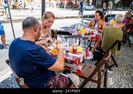 Einheimische essen traditionelles Essen in Einem Café auf dem Ipanema Sunday Market (Hippie Fair), Rio de Janeiro, Rio de Janeiro State, Brasilien. Stockfoto