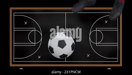 Person mit Fußballschuhen, die auf der Tafel steht und ein Fußballfeld darauf gezeichnet ist Stockfoto