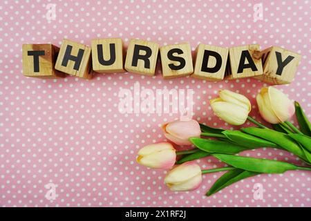 Donnerstag Buchstaben mit Tulpe flowes Bouquet von oben auf Polka Dot Hintergrund Stockfoto