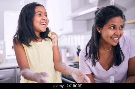 Mädchen, Mutter und spielen mit Mehl oder lachen in der Küche, backen und Spaß mit Zutaten zu Hause. Tochter, Mama und Binding oder indische Familie für Stockfoto