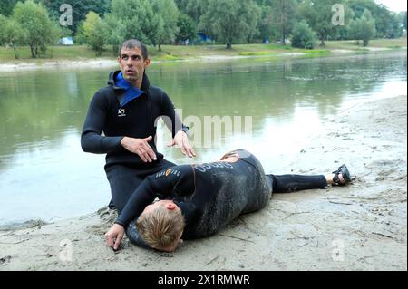 Rettungsschwimmer zeigt die Position des ertrinkenden Körpers, bevor er die Reanimation durchführt, indem er mit den Händen auf die Brust eines Ertrinkenden drückt. August 2018. Kiew, Ukrainisch Stockfoto