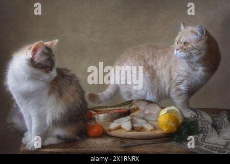 Zwei Katzen auf einem Tisch mit geräuchertem Fisch Stockfoto