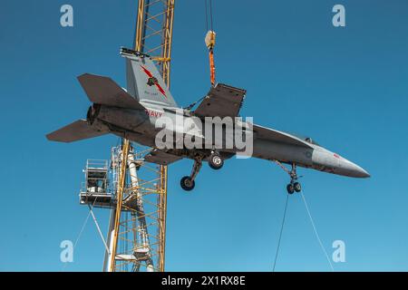 NORFOLK, Virginia (15. April 2024) Ein Kran, der von Naval Facilities Engineering Systems Command betrieben wird, hebt ein Trainingsflugzeug auf, das für Flugschäden eingesetzt wird Stockfoto