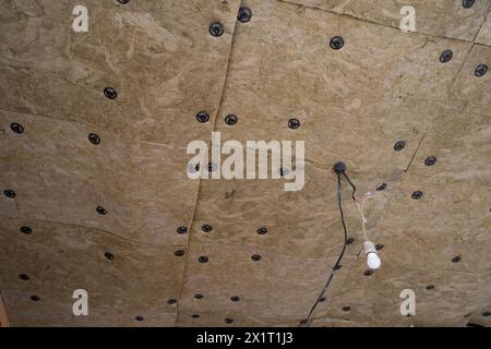 Dämmplatten aus Mineralwolle, die an der Decke verklebt wurden. Stockfoto