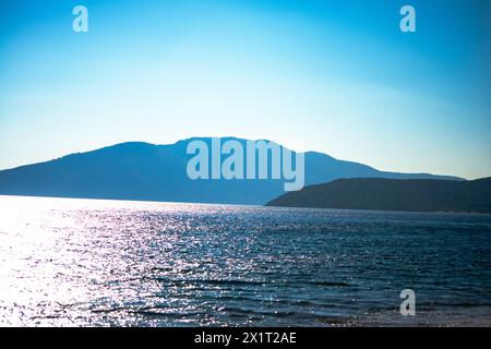 Tauchen Sie ein in die ruhige Schönheit der Küstenzone, wo das ruhige blaue Meer auf die Sandküste trifft. Stockfoto