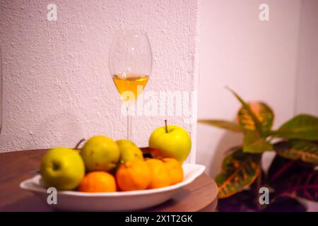 Genießen Sie die köstliche Kombination aus Mandarinen, grünen Äpfeln und einem Glas Wein für einen erfrischenden und geschmackvollen Genuss. Stockfoto