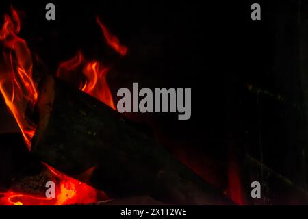Fangen Sie die Essenz des Inferno mit einer Nahaufnahme des feurigen Holzfeuers mit brennenden Flammen und sengender Hitze ein. Stockfoto