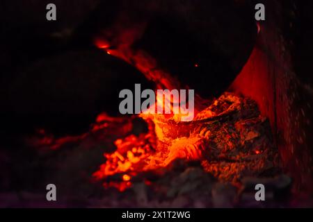 Fangen Sie die Essenz des Inferno mit einer Nahaufnahme des feurigen Holzfeuers mit brennenden Flammen und sengender Hitze ein. Stockfoto