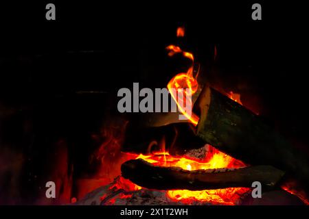 Fangen Sie die Essenz des Inferno mit einer Nahaufnahme des feurigen Holzfeuers mit brennenden Flammen und sengender Hitze ein. Stockfoto