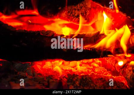 Fangen Sie die Essenz des Inferno mit einer Nahaufnahme des feurigen Holzfeuers mit brennenden Flammen und sengender Hitze ein. Stockfoto