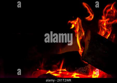 Fangen Sie die Essenz des Inferno mit einer Nahaufnahme des feurigen Holzfeuers mit brennenden Flammen und sengender Hitze ein. Stockfoto