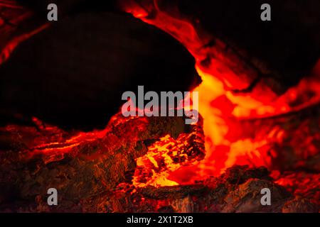 Fangen Sie die Essenz des Inferno mit einer Nahaufnahme des feurigen Holzfeuers mit brennenden Flammen und sengender Hitze ein. Stockfoto
