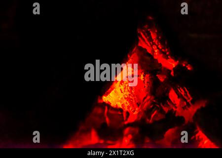 Fangen Sie die Essenz des Inferno mit einer Nahaufnahme des feurigen Holzfeuers mit brennenden Flammen und sengender Hitze ein. Stockfoto
