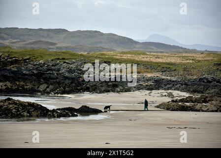 Mann am Strand mit Hund. Allein in der Natur an einem einsamen Strand in Ardara, County Donegal, Irland. Stockfoto