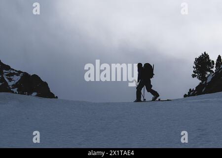 Athleten, die an einem sonnigen Tag im Hinterland Ski fahren, mit einer Landschaft aus verschneiten Bergen. Sonnenuntergang über den schneebedeckten Bergen. Stockfoto