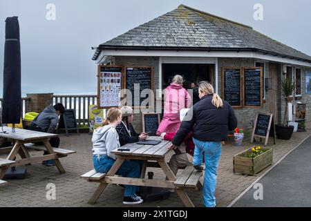 Menschen Besucher Urlauber, die an einem Picknicktisch am Hannafore Kiosk in Looe in Cornwall in Großbritannien sitzen. Stockfoto