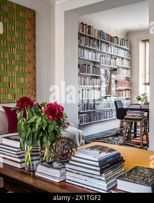 Schneiden Sie Blumen auf einem Couchtisch mit gestapelten Büchern in Chelsea Home, London, Großbritannien Stockfoto