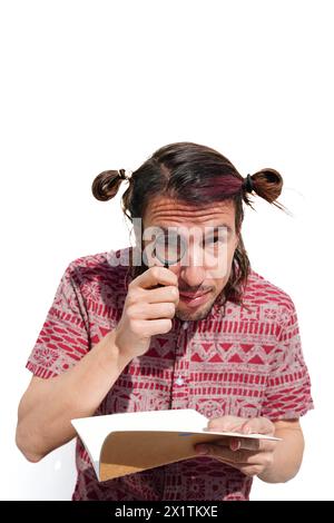 Ein neugieriger Mann mit einer Lupe sucht ein Buch zur Untersuchung Stockfoto
