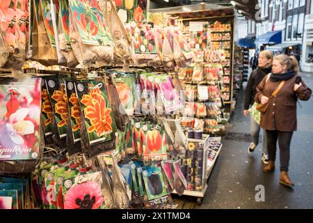 Auf dem farbenfrohen, schwimmenden Blumenmarkt Bloemenmarkt auf dem Singel im Zentrum von Amsterdam, Niederlande, spazieren Besucher vorbei an Blumensamen Stockfoto