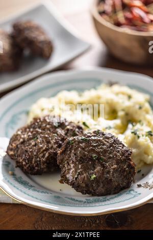 Hackfleischkoteletts mit Kartoffelpüree und geklärter Butter. Traditionelle slowakische Fleischbällchen - Fasirky mit Kartoffelpüree. Stockfoto