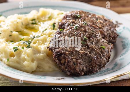 Hackfleischkoteletts mit Kartoffelpüree und geklärter Butter. Traditionelle slowakische Fleischbällchen - Fasirky mit Kartoffelpüree. Stockfoto