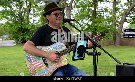 Mann spielt Gitarre im Freien auf dem Bauernmarkt. Stockfoto