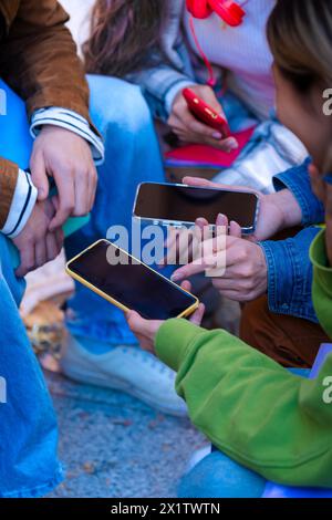 Vertikales Porträt nicht erkennbarer Schüler mit Mobiltelefonen, die Inhalte in sozialen Netzwerken erstellen Stockfoto