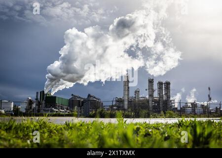 ROTTERDAM – Außenansicht der Raffinerien im Hafen von Rotterdam, die CO2 bei dunklem Himmel von einem Regenschauer im Hintergrund ausstoßen. niederlande aus - belgien aus Stockfoto