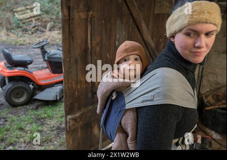 Junge Mutter mit ihrem Sohn, 8 Monate, in einer Schlinge auf dem Rücken, Mecklenburg-Vorpommern, Deutschland Stockfoto