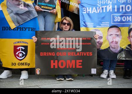 Ukrainische Frau posiert mit dem Banner "bring Out Relatives Home" auf einer friedlichen Demonstration für die Freilassung der gefangenen ukrainischen Verteidiger aus russischen Gefängnissen. Kiew - 13. April 2024 Stockfoto