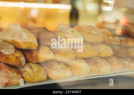 Ein Stapel Brotlaibe wird im Fenster der Bäckerei angezeigt Stockfoto