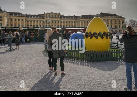 Ein Paar schaut sich ein großes, dekoratives Osterei vor dem herrlichen Ostermarkt Schloss Schönbrunn an Stockfoto