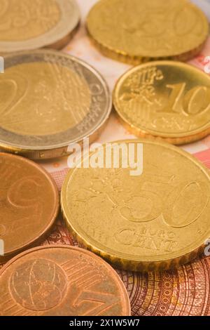 Nahaufnahme von Gold- und kupferfarbenen Münzen mit fünf, zehn, fünfzig Euro-Cent-Münzen auf Euro-Banknote, Studio-Komposition, Quebec, Kanada Stockfoto