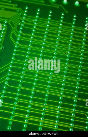 Nahaufnahme einer fluoreszierenden grün beleuchteten elektronischen Computerplatine mit Linien und silbernen Lötpunkten, Studio Composition, Quebec, Kanada Stockfoto